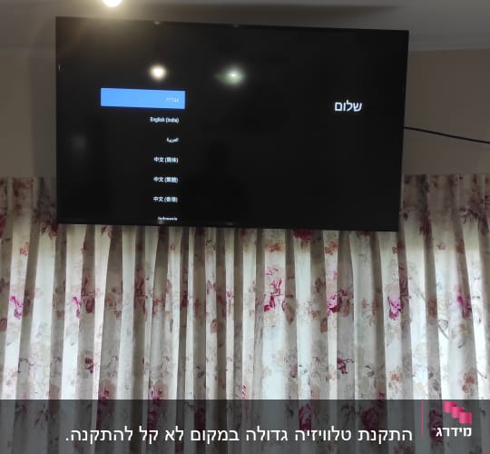 טלוויזיה תלויה על הקיר עם תפריט שפות
